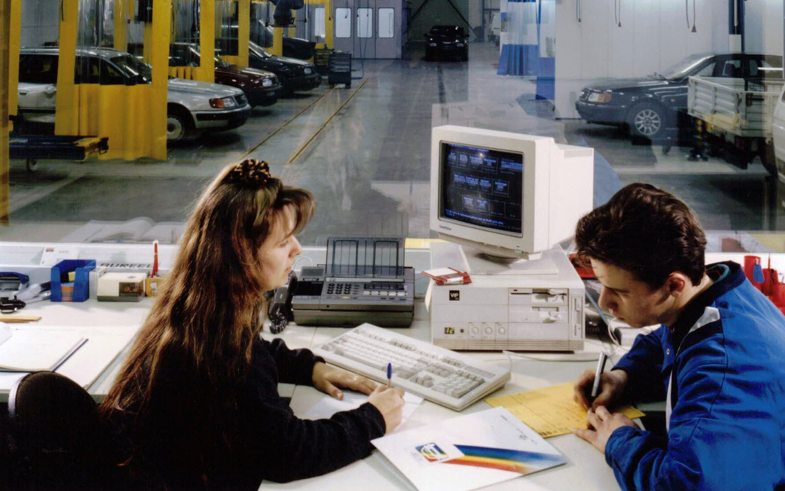 Wonitrol in de jaren '90: Kristien en een collega aan het werk in het bureau, met de werkplaats op de achtergrond.